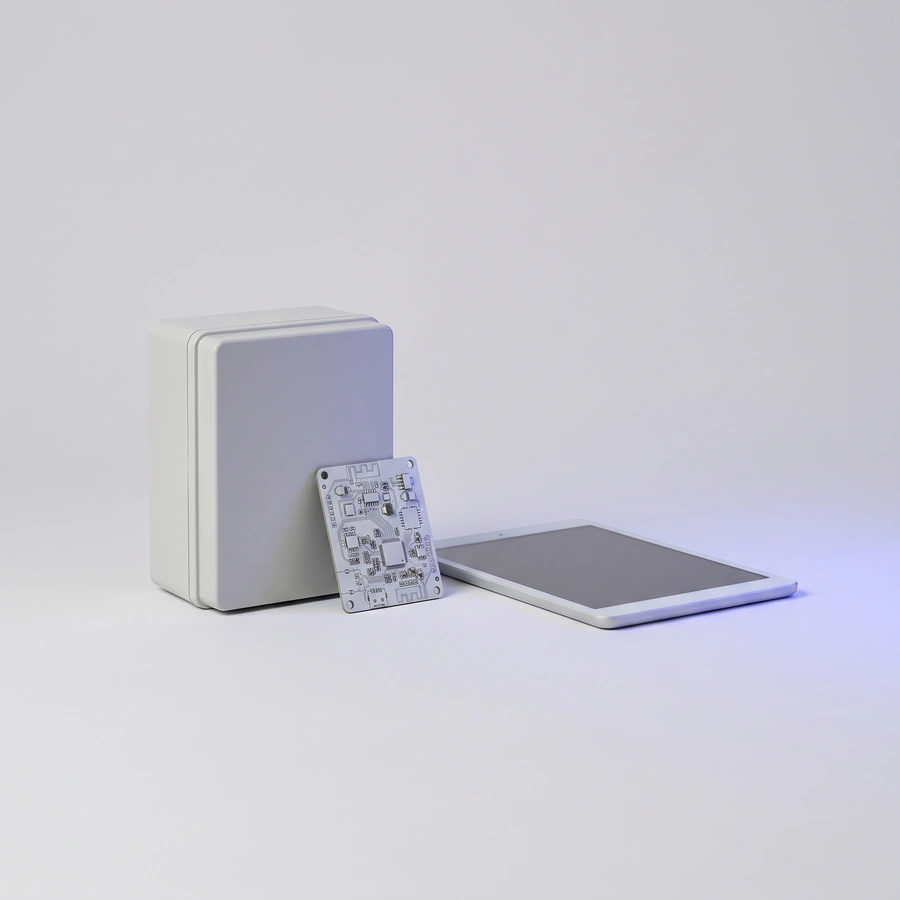 A circuit board leaning on a white enclosure next to a tablet